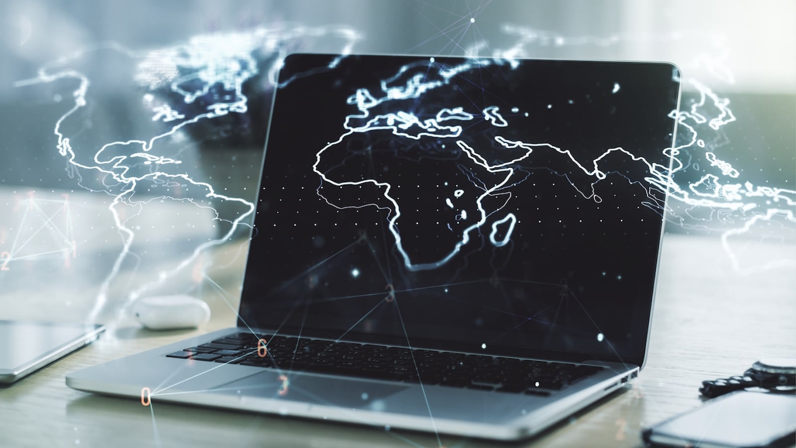 photo of laptop behind superimposed digital map of world