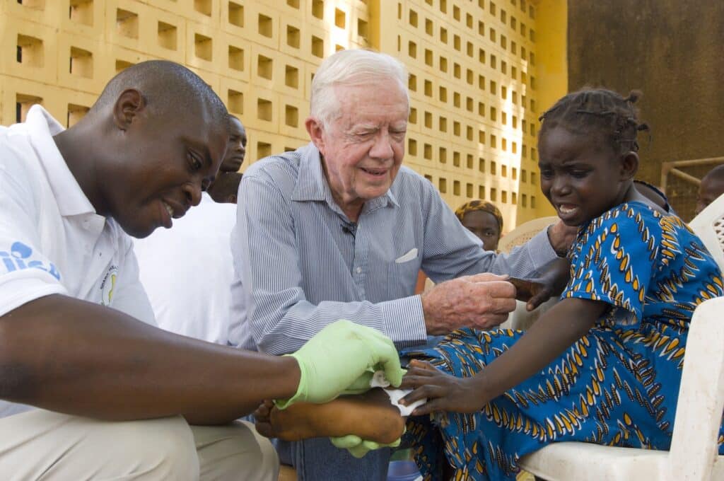 Carter and Adams Bawa dressing the Guinea worm wound of a girl in Ghana