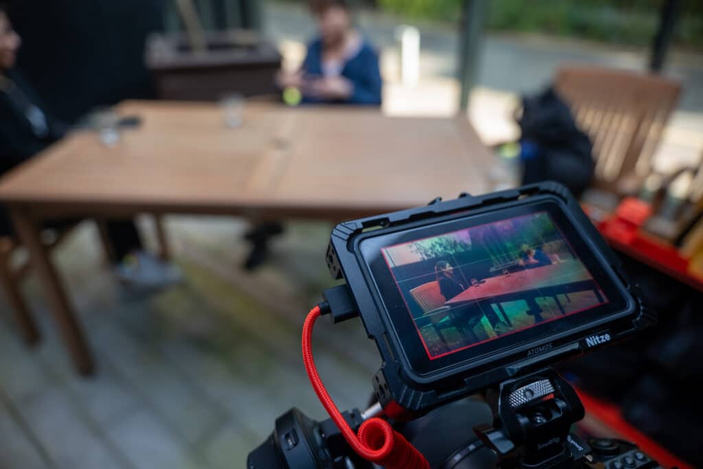 Jenny Reardon and Suze speaking viewed through camera monitor