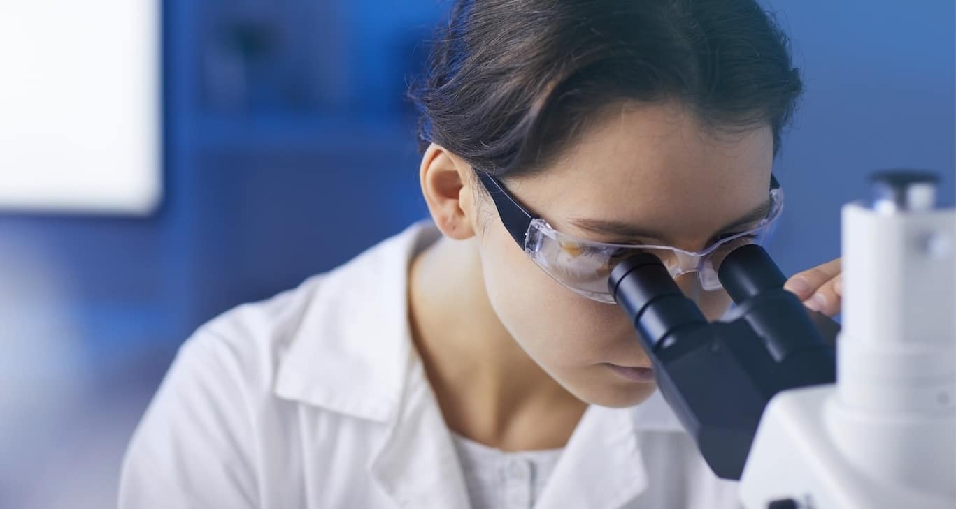 Lab tech using microscope